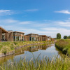 Modern holiday cottages by the water at Water Village holiday park in Zeeland, Netherlands, sunny day.