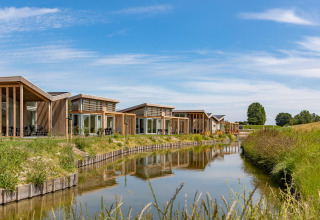 Cottages de vacances modernes au bord de l’eau, Water Village à Zeeland, Pays-Bas, journée ensoleillée.