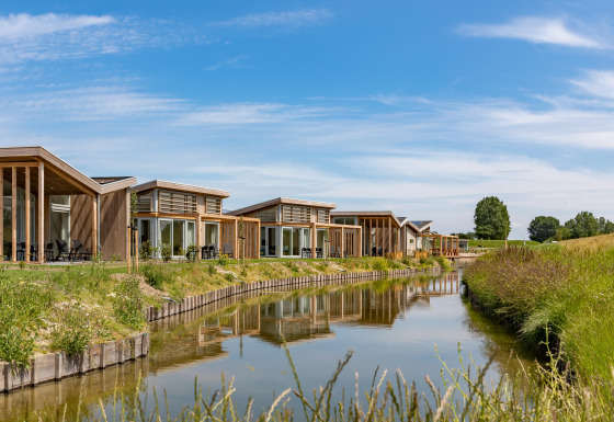 Moderne Ferienhäuser am Wasser im Water Village Ferienpark in Zeeland, Niederlande, bei sonnigem Wetter.