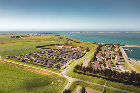 Luftaufnahme vom Water Village Ferienpark in Zeeland, Niederlande, mit Meerblick und viel Grün.
