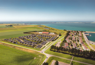 Luftaufnahme vom Water Village Ferienpark in Zeeland, Niederlande, mit Meerblick und viel Grün.