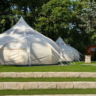 Spacious glamping tents at Camping Gugel set on grass with trees around, offering comfort in Baden-Württemberg.