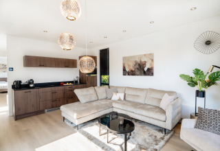 Lichte, moderne woonkamer en keuken in Villa «Bloomingdale» bij MarinaPark Residentie Bloemendaal in Nederland.