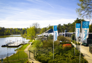 Udsigt over søen og ferieparken Bospark 't Wolfsven i North-Brabant, Holland, med svanebåde og flag.