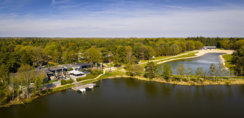 Luchtfoto van Bospark 't Wolfsven vakantiepark in Noord-Brabant, Nederland, omgeven door bossen en meren.