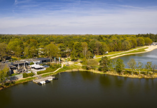 Aerial view of Bospark 't Wolfsven holiday park in North Brabant, Netherlands, surrounded by trees and lakes.