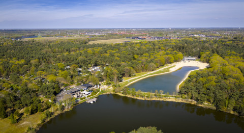 Luftfoto af Bospark 't Wolfsven feriepark i det grønne landskab i Nord-Brabant, Holland med sø og skov.
