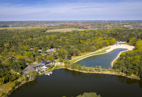 Luchtfoto van Bospark 't Wolfsven vakantiepark in Noord-Brabant, Nederland met meren, strand en bossen.
