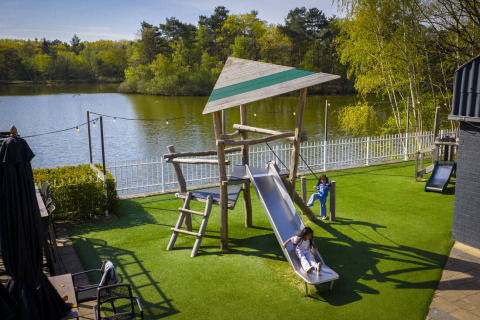 Kinderen spelen op de speeltuin aan het meer bij Bospark ’t Wolfsven, vakantiepark in Noord-Brabant, Nederland.