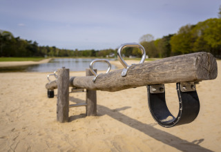 Altalena di legno su un parco giochi sabbioso vicino a un lago al Bospark 't Wolfsven, Brabante Settentrionale, Paesi Bassi.
