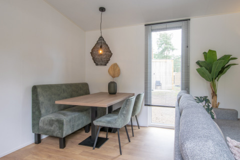 Coin repas moderne avec sièges verts et suspension dans Timber Cottage 4, Bospark 't Wolfsven, Pays-Bas.