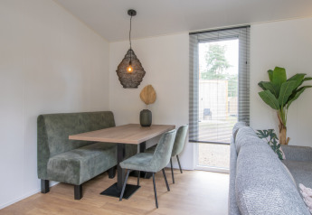 Moderne spisehjørne med grønne møbler og pendellampe i et lille hus, Timber Cottage 4, Bospark 't Wolfsven.