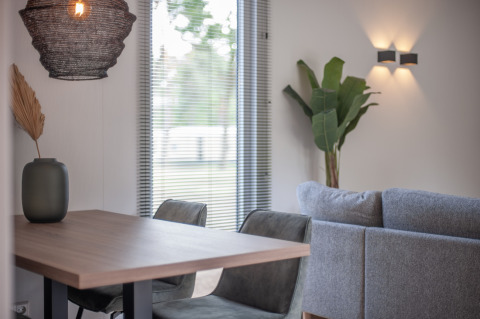 Modernes, helles Wohnzimmer und Essbereich im Timber Cottage 4 im Bospark 't Wolfsven, Niederlande.