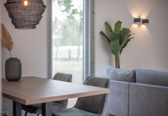 Modernes, helles Wohnzimmer und Essbereich im Timber Cottage 4 im Bospark 't Wolfsven, Niederlande.