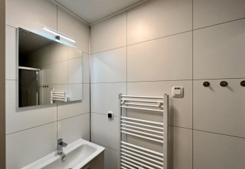 Modernes Badezimmer in Timber Cottage 6 mit Spiegel, Waschbecken und Handtuchheizkörper in Bospark 't Wolfsven.