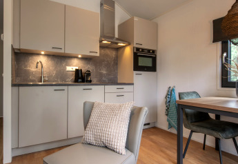 Moderne compacte keuken en eetgedeelte in Tiny House 2 bij Bospark 't Wolfsven, Nederland.