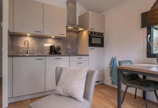 Cuisine moderne et compacte avec coin repas dans Tiny House 2 à Bospark 't Wolfsven, Pays-Bas.