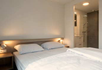 Slaapkamer in Tiny House 2 op Bospark 't Wolfsven in Nederland met tweepersoonsbed en badkamer.