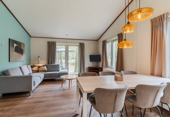Sala y comedor en el chalet WVR6 de Bospark 't Wolfsven, Países Bajos, con muebles modernos y luz natural.