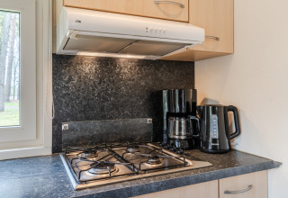 Esquina de cocina en el chalet WVR6, Bospark 't Wolfsven, con cocina de gas, cafetera y hervidor.