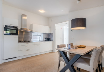 Moderne, kompakt køkken og spisestue i en Lodge 4, Bospark 't Wolfsven, Holland, med lyst interiør.