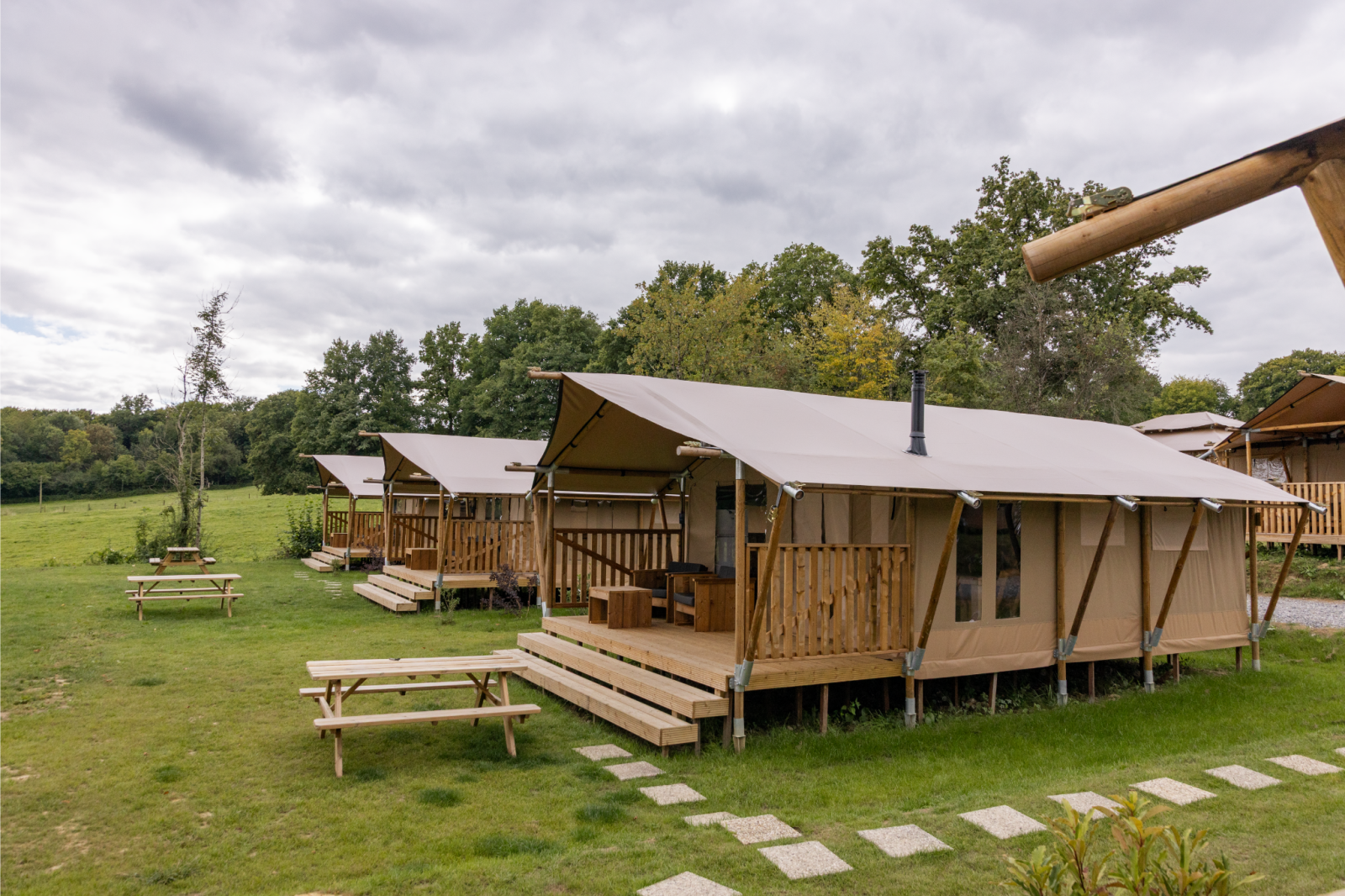 Interieur van een safaritent met tweepersoonsbed bij Comet 27 Lodges in Arden Parks, Signy l'Abbaye, Frankrijk.