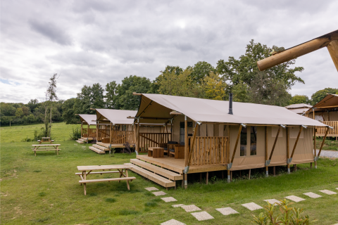 Tiendas safari en Comet 27 Lodges, Arden Parks - Signy l'Abbaye, Francia, rodeadas de naturaleza verde.