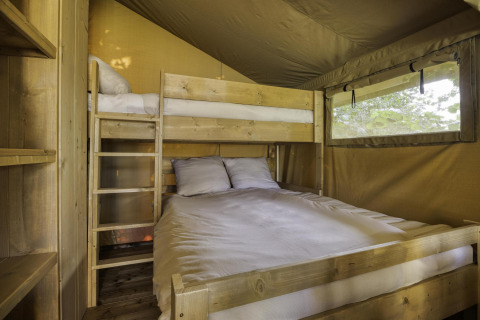 Zona de dormitorio en tienda safari Comet 27 Lodges, Arden Parks Signy l'Abbaye, con litera y ventana.