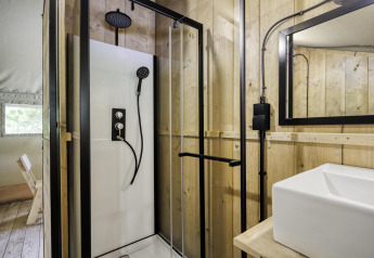 Moderne badkamer met douchecabine en wastafel in Comet 27 Lodges safaritent bij Arden Parks, Frankrijk.