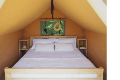 Intérieur d'une tente safari avec un lit double à Arden Parks - Signy l'Abbaye, France.