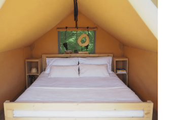 Interno di una tenda safari con letto matrimoniale ad Arden Parks - Signy l'Abbaye, Francia.