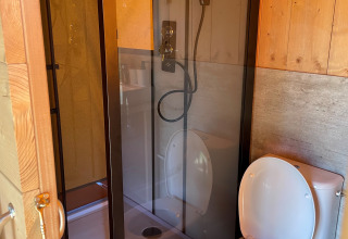 Salle de bain dans une tente safari à Arden Parks, Signy l’Abbaye : douche fermée et toilettes voisines.