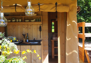 Tente safari « Shimmer » à Arden Parks, Signy l'Abbaye, France avec cuisine extérieure en bois accueillante.