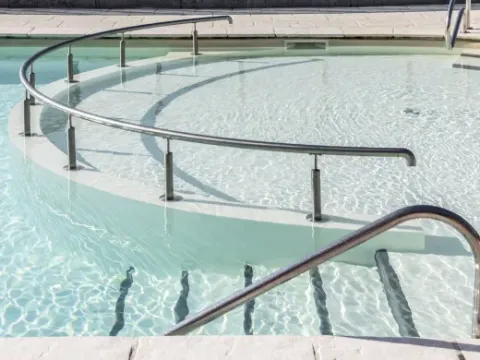 Runde Poolrampe mit Handlauf im Arden Parks - Signy l'Abbaye, Ferienpark in Grand Est, Frankreich.