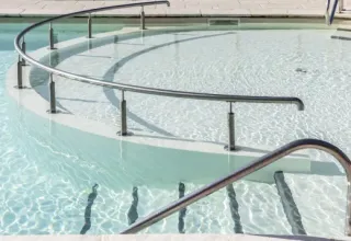 Rampa curva de piscina con barandilla en Arden Parks - Signy l'Abbaye, parque vacacional en Grand Est, Francia.