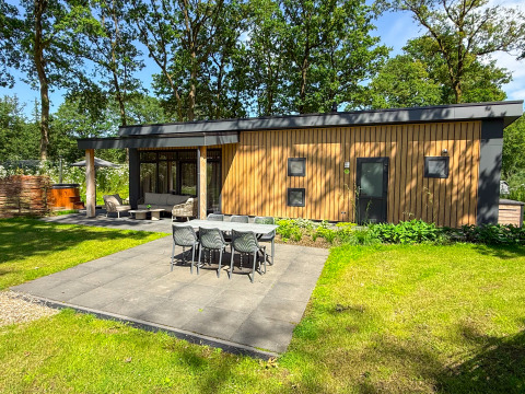 Moderno Wood Cottage al Camping de Witte Berg nei Paesi Bassi con patio e area pranzo esterna.