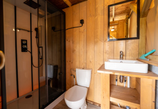 Baño en la tienda Safari 2 en Lauwersmeer, Países Bajos, con ducha, inodoro y lavabo moderno.