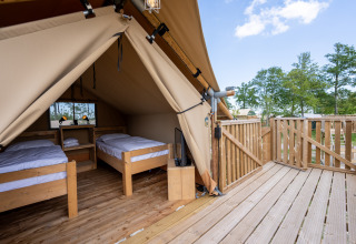 Interno della Safari tent 2 a Lauwersmeer, Paesi Bassi, con due letti singoli e terrazza in legno.