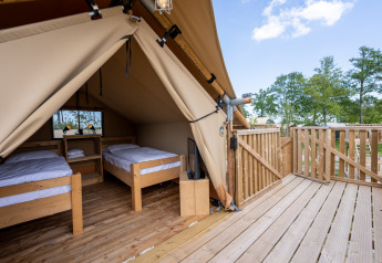 Interior de la Safari tent 2 en Lauwersmeer, Países Bajos, con dos camas individuales y terraza de madera.