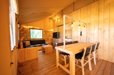 Interior de la tienda Safari 6 en Lauwersmeer, Países Bajos, con muebles de madera y ambiente acogedor.