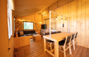 Interno della tenda Safari 6 al Lauwersmeer nei Paesi Bassi, con arredi in legno e illuminazione accogliente.