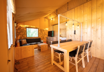 Interno della tenda Safari 6 al Lauwersmeer nei Paesi Bassi, con arredi in legno e illuminazione accogliente.