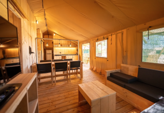 Interno della tenda Safari 6 al Lauwersmeer, Paesi Bassi, con arredi in legno, cucina e soggiorno.