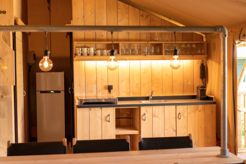 Interno cucina in legno nella Safari tent 6 a Lauwersmeer, Paesi Bassi, con illuminazione calda.