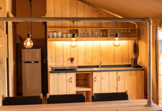 Interno cucina in legno nella Safari tent 6 a Lauwersmeer, Paesi Bassi, con illuminazione calda.