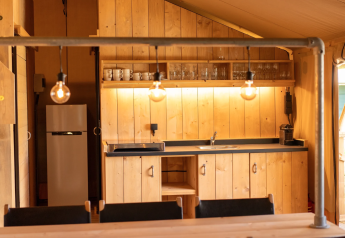 Interno cucina in legno nella Safari tent 6 a Lauwersmeer, Paesi Bassi, con illuminazione calda.