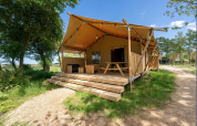 La tienda Safari 8 en Lauwersmeer, Países Bajos, cuenta con terraza de madera y entorno natural verde.
