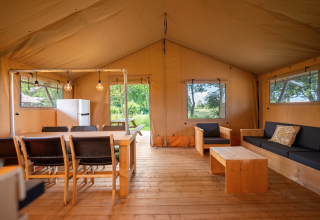 Interno della tenda Safari 8 a Lauwersmeer, Paesi Bassi, con arredi in legno e spazio confortevole.