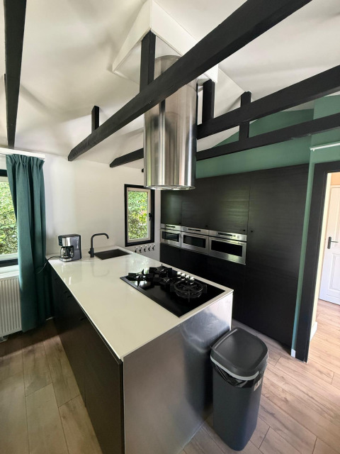 Moderne keuken in het «Private» Lodge bij Het Verscholen Dorp, Nederland, met zwarte balken en design.