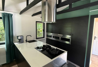 Moderne keuken in het «Private» Lodge bij Het Verscholen Dorp, Nederland, met zwarte balken en design.